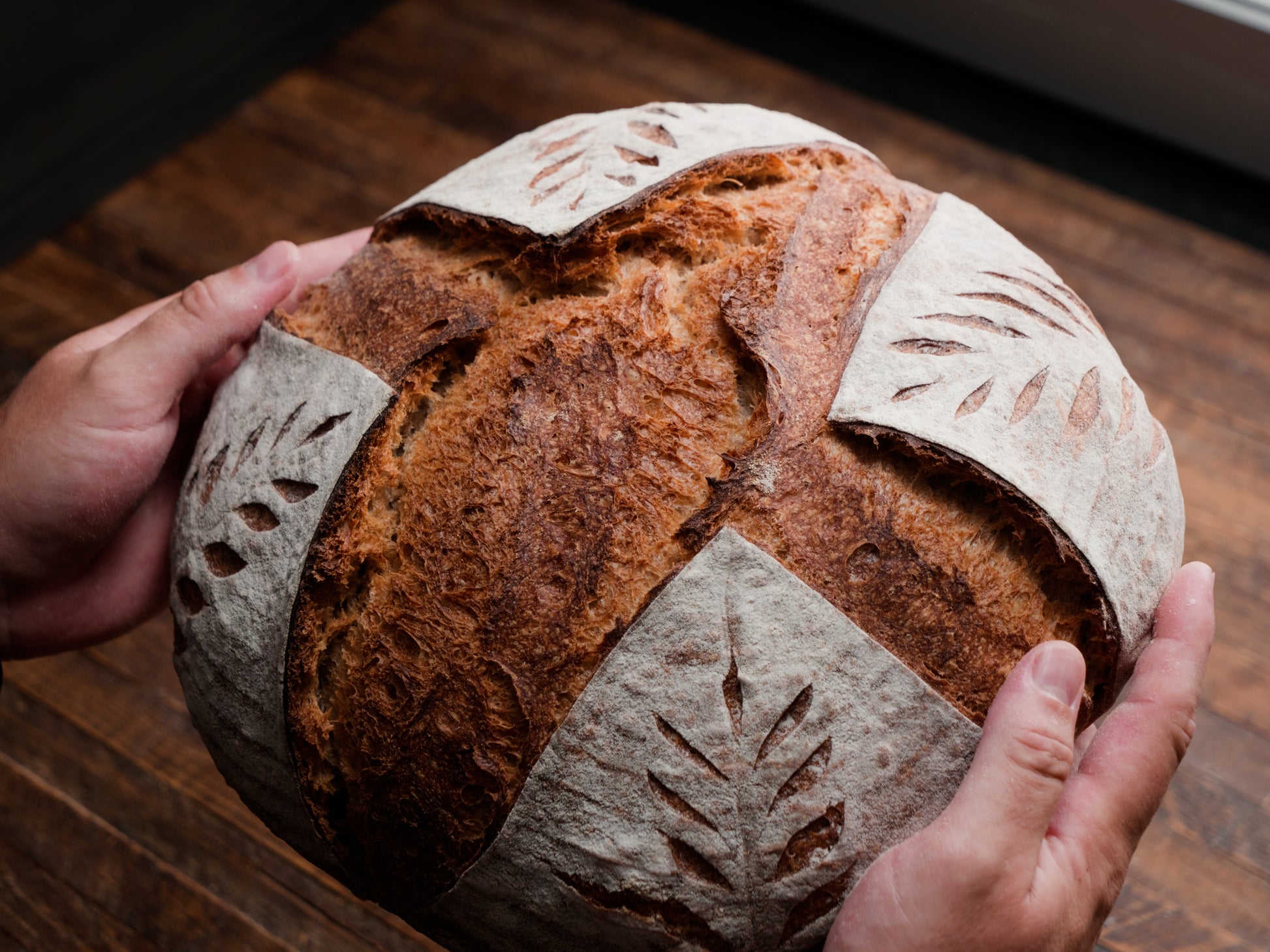 Rouge de Bordeaux Sourdough Miche held in hands for bread shipping nationwide.